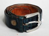 ceinture en cuir bleu avec une boucle argentée sur un fond blanc