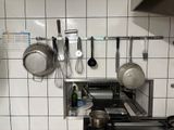 des casseroles et des poêles sont accrochées au mur d'une cuisine