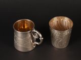 two silver cups sitting next to each other on a table