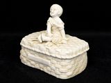 figurine en porcelaine blanche représentant un garçon assis sur une caisse en briques