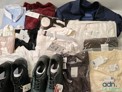 Plusieurs paires de chaussures, des chemises, des pantalons et d'autres vêtements sont exposés