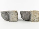two cement bowls sitting next to each other on a white surface