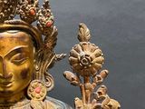 a gold statue of a woman with a crown on her head