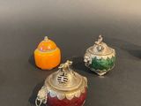 three teapots sitting on a table with oranges in the background