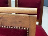a wooden chair with a red velvet upholstered seat