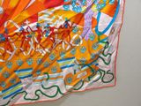 a colorful scarf hanging on a wall with a picture on it