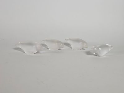 trois oiseaux en verre transparent posés sur une surface blanche