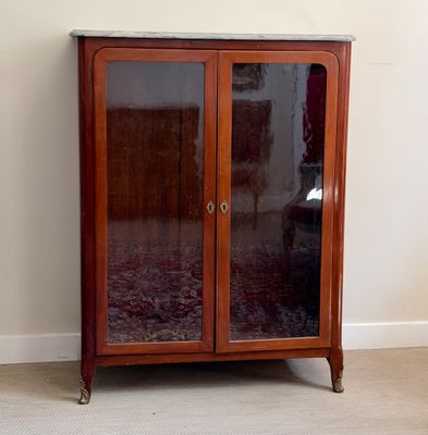 un meuble en bois avec des portes en verre dans le coin d'une pièce