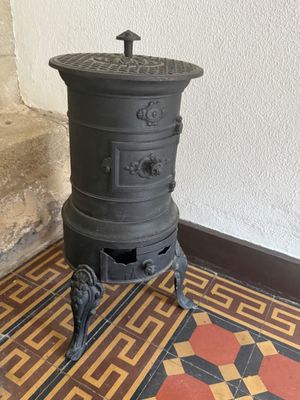 an old stove sits on a tiled floor in a room