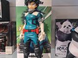 anime figurines are displayed on a glass shelf in a store