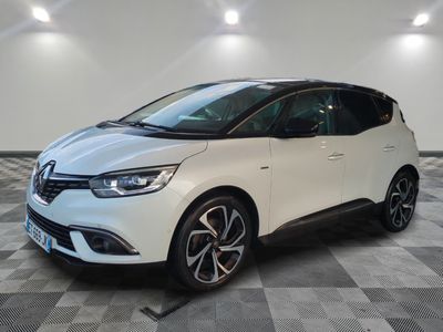 une voiture blanche est garée dans une pièce au sol à carreaux