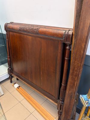 un lit avec un cadre en bois et une porte vitrée