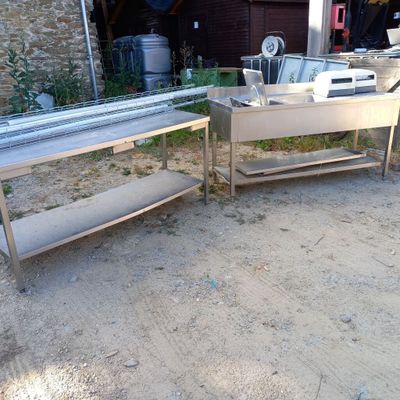 deux tables en acier inoxydable et un évier dans une cour