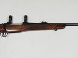 un fusil accroché au mur, avec une arme posée dessus