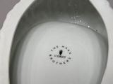 underside view of a white porcelain urinal with a hole in the middle