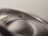 a close up of a silver ring with a diamond on it