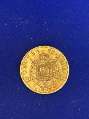 gros plan d'une pièce d'or sur une surface bleue