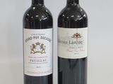 two bottles of wine sitting next to each other on a table