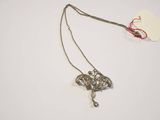 a close up of a necklace on a white surface with a tag