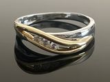 a close up of a gold and silver ring on a black surface