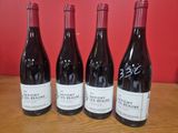 trois bouteilles de vin sont alignées sur une table en bois