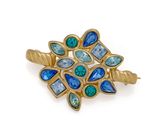 a close up of a gold ring with blue and green stones