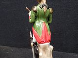 a figurine of a man with a gun on a pedestal