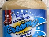 un pot de beurre de cacahuète posé sur un plan de travail