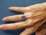 a woman ' s hand with a blue ring on it