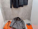 a room with a bed, jacket, and other items on the floor