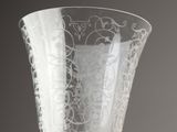 a glass vase with a design on it sitting on a table