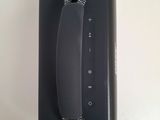 a black phone hanging on the wall next to a white wall