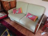 un canapé vert avec des coussins colorés dans un salon