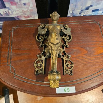 une petite table en bois sur laquelle se trouve une statuette en laiton