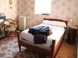 un lit dans une chambre avec une cheminée et un fauteuil