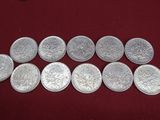 a close up of a bunch of silver coins on a table