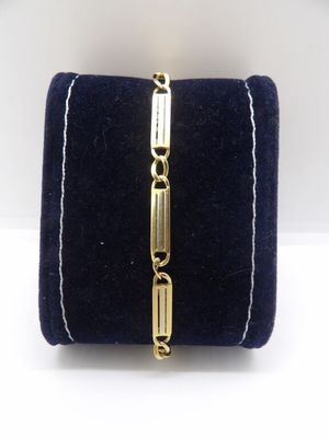 un gros plan d'un bracelet en or posé sur un étui en velours bleu