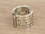 a silver ring on a wooden table with a white background