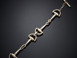un gros plan d'un bracelet en métal muni d'un fermoir, sur fond noir