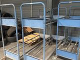 two blue metal beds sitting in a garage next to a pile of tires