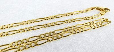 a pair of gold chain bracelets on a white surface