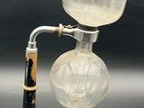 a glass beaker with a metal handle and a glass beaker with a black handle
