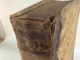 an old book sitting on top of a white table next to a lamp