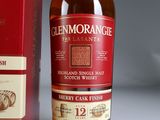 a bottle of whisky next to a box of wine