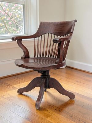 a wooden chair sitting in front of a window on a hard wood floor