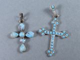 deux pendentifs en forme de croix, en argent et turquoise, sur un fond gris