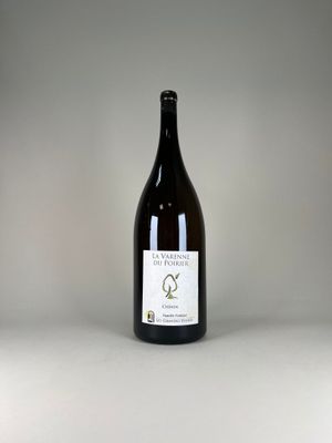 une bouteille de vin posée sur une table blanche