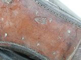 a close up of a brown shoe with rivets on it