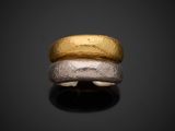 a close up of a gold and silver ring on a black surface