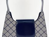 sac à main gris et bleu avec une poignée en cuir noir sur fond blanc